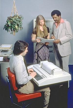 A man sitting at a DECwriter teletype terminal